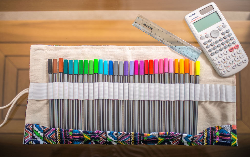 A picture of some pens, a ruler and a calculator.